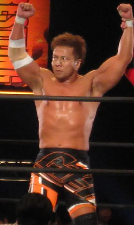 Kojima raises both arms in the ring