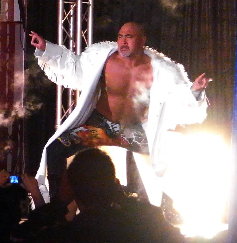 Keiji Mutoh in a white fur coat, pointing to the crowd at his entrance