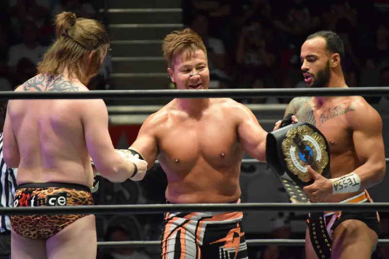 Kojima, with David Finlay and Ricochet, holds the NEVER six-man belt